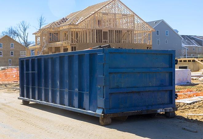 stack of residential dumpsters in a driveway, waiting for pickup